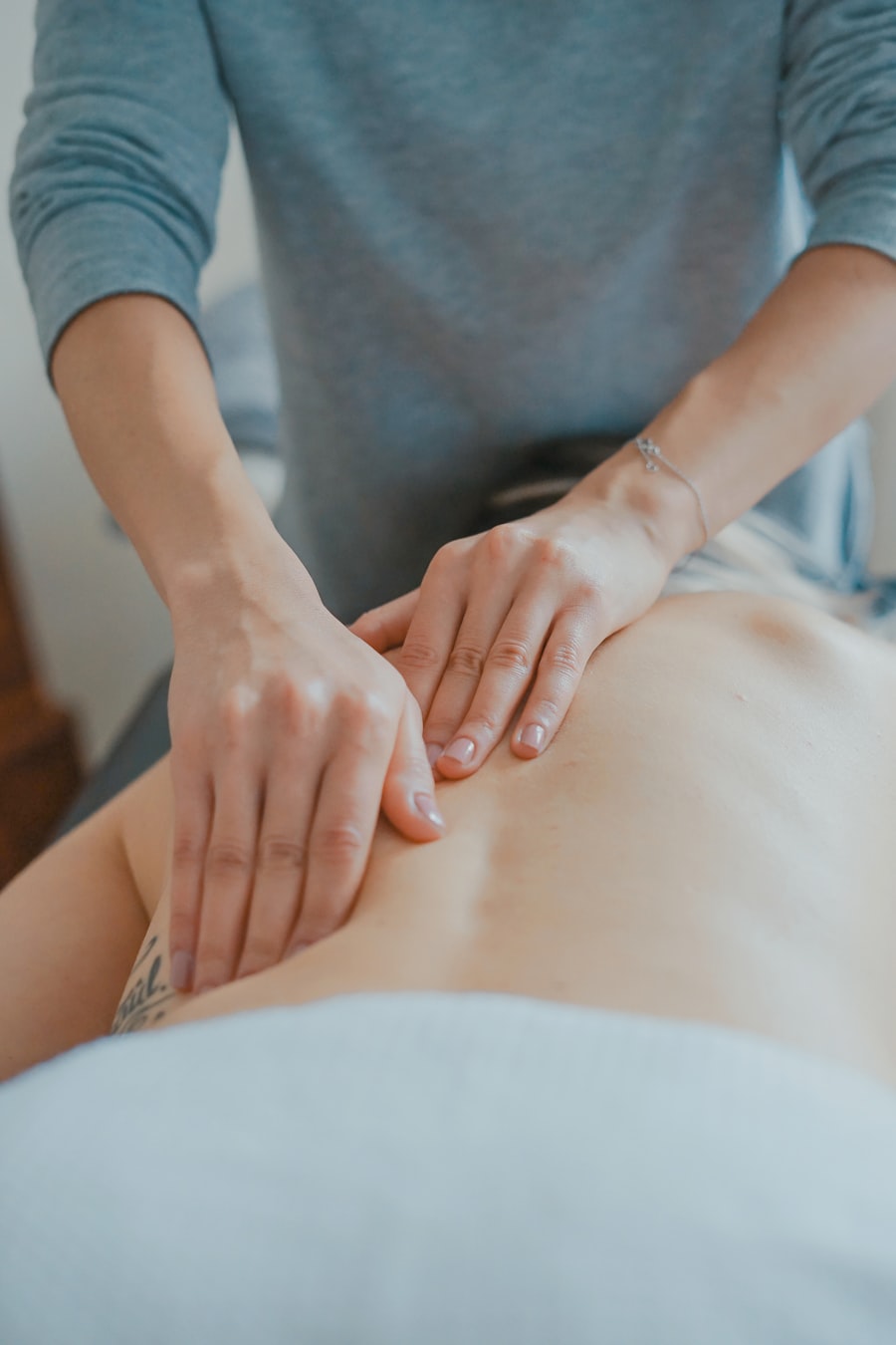 Hands performing myofascial release on a patient's back
